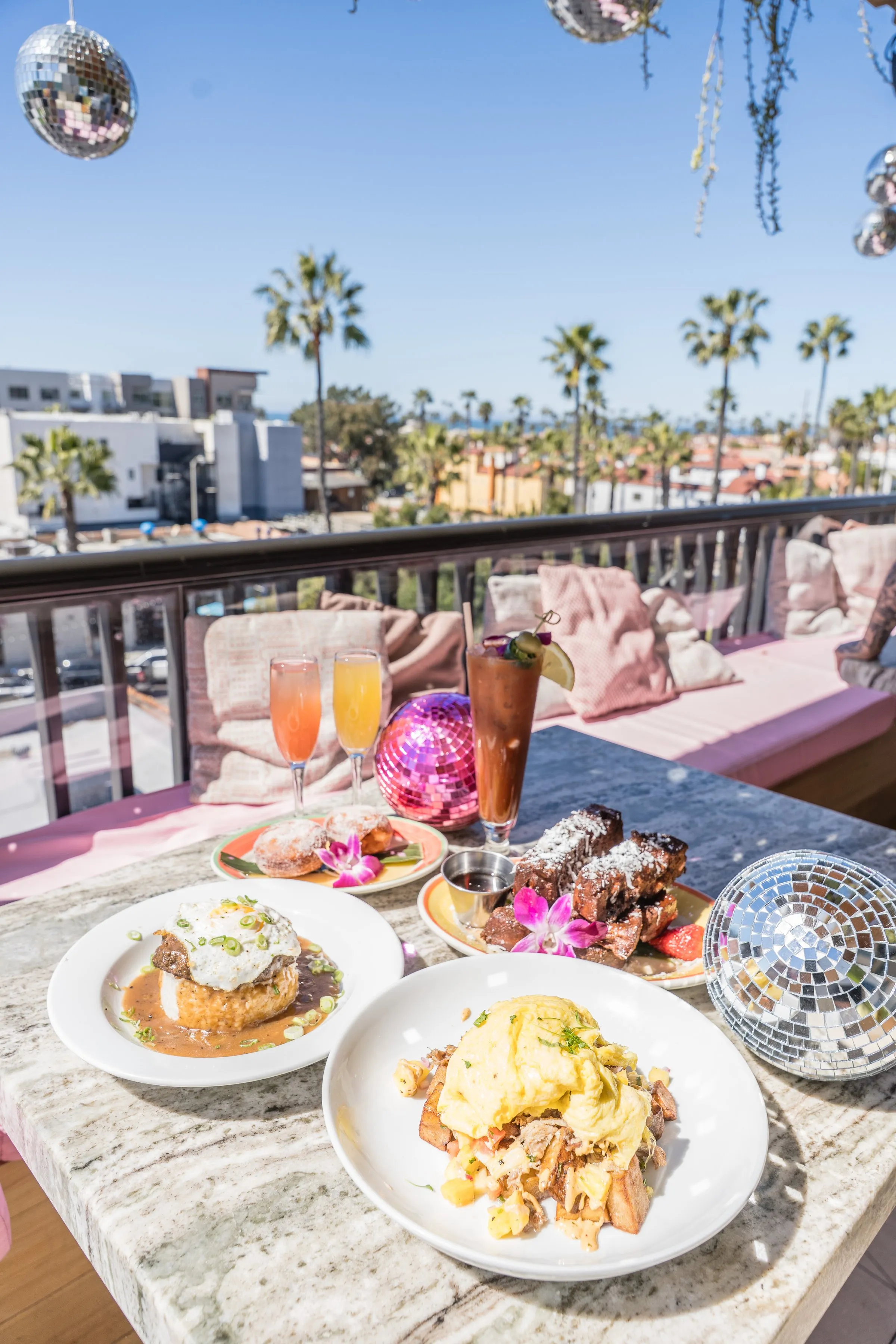 Cococabana rooftop brunch setup with disco balls, mimosas, and palms