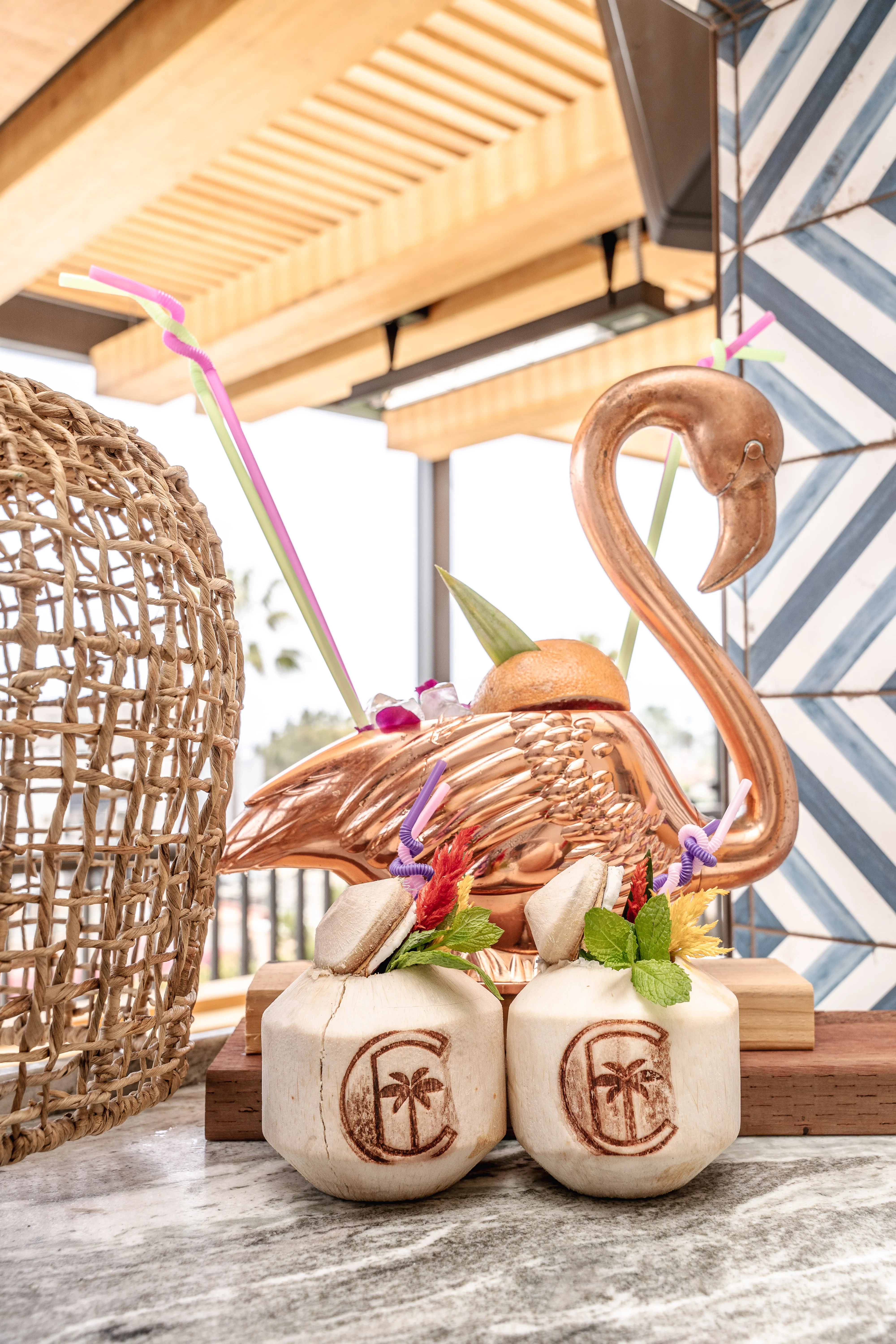 Coco Cabana branded coconut cups with copper flamingo vessel and colorful straws