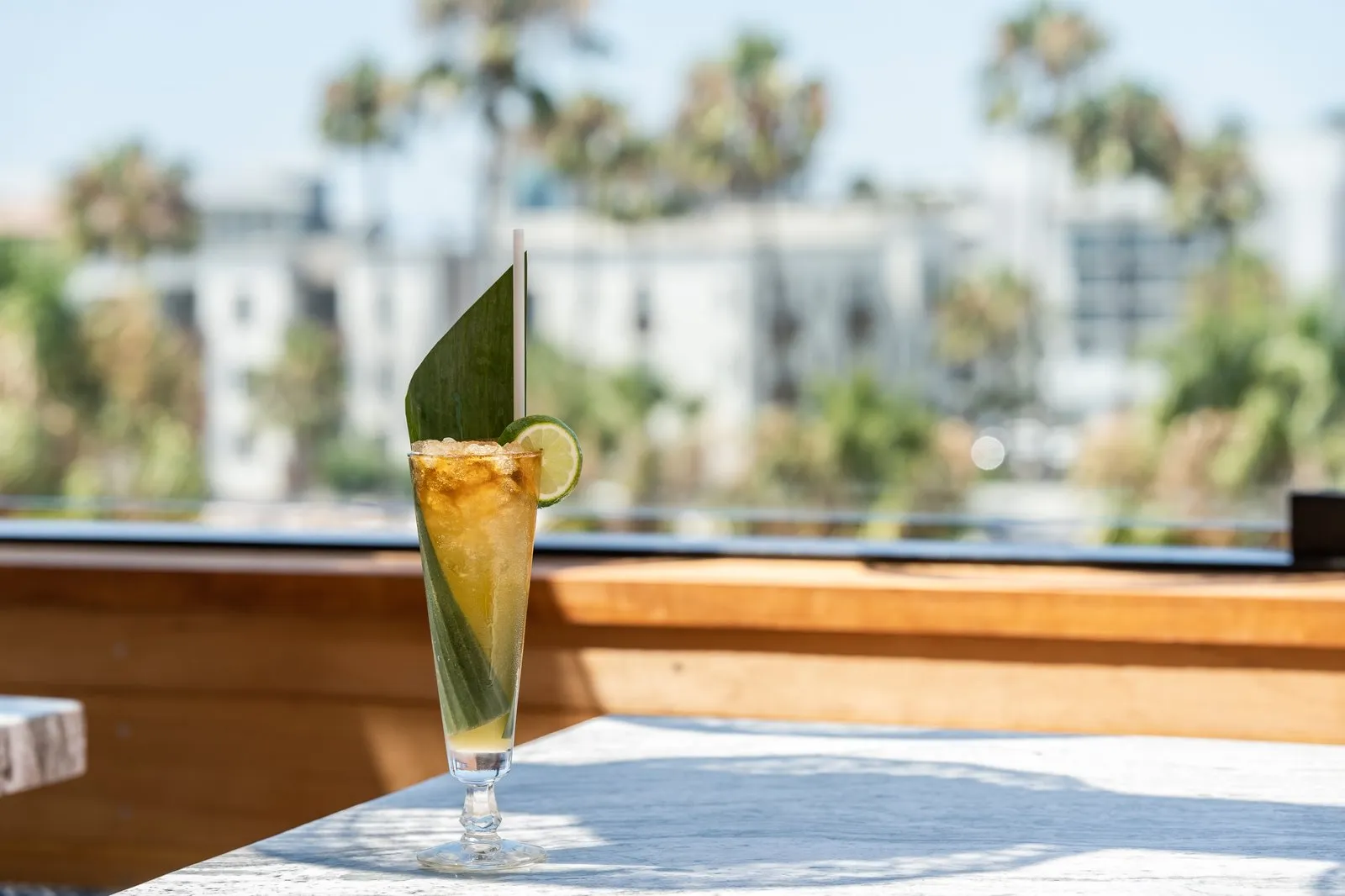 Miami Pound Machine cocktail with banana leaf and lime wheel