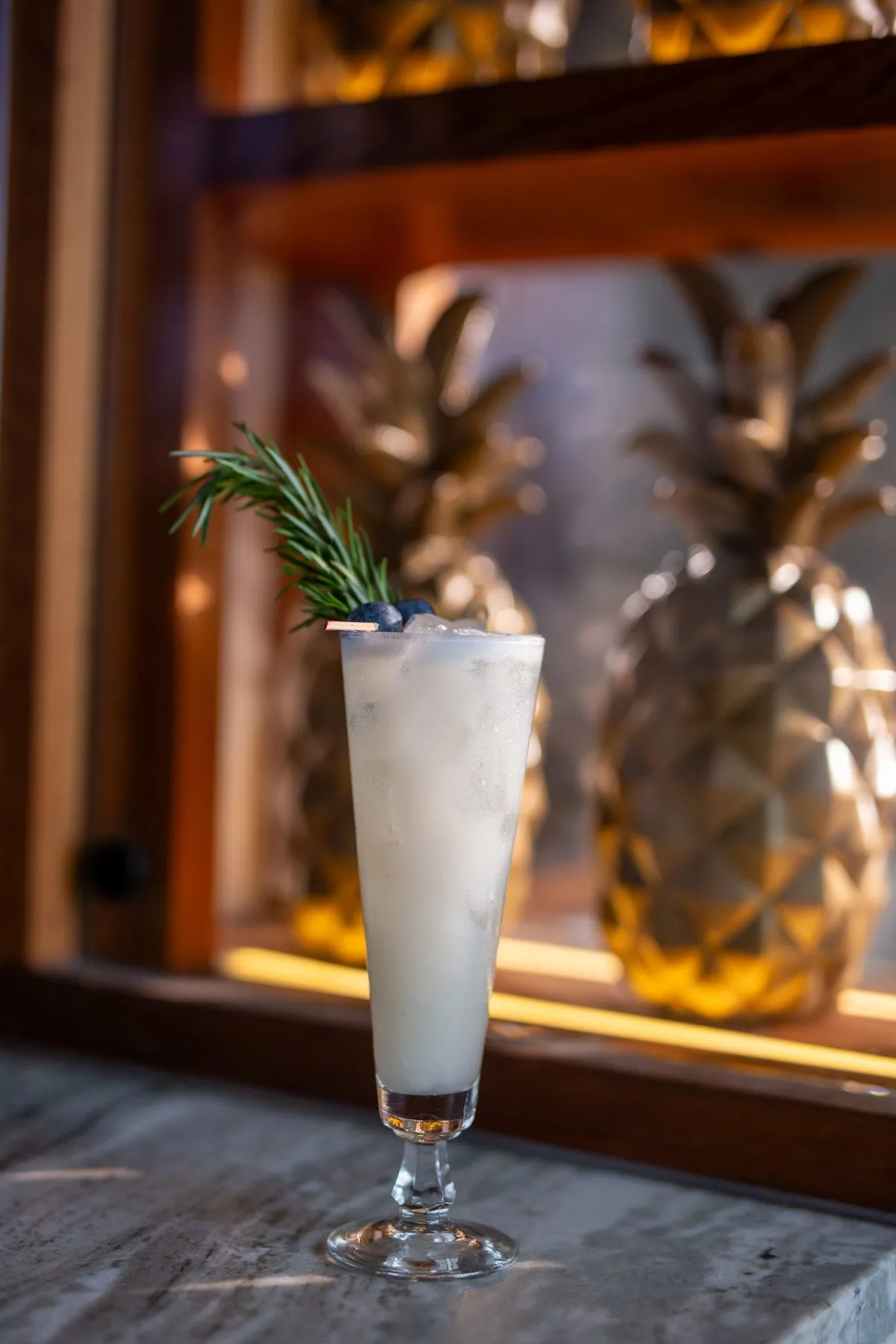 Coco Cabana cocktail in front of the illuminated gold pineapple wall display