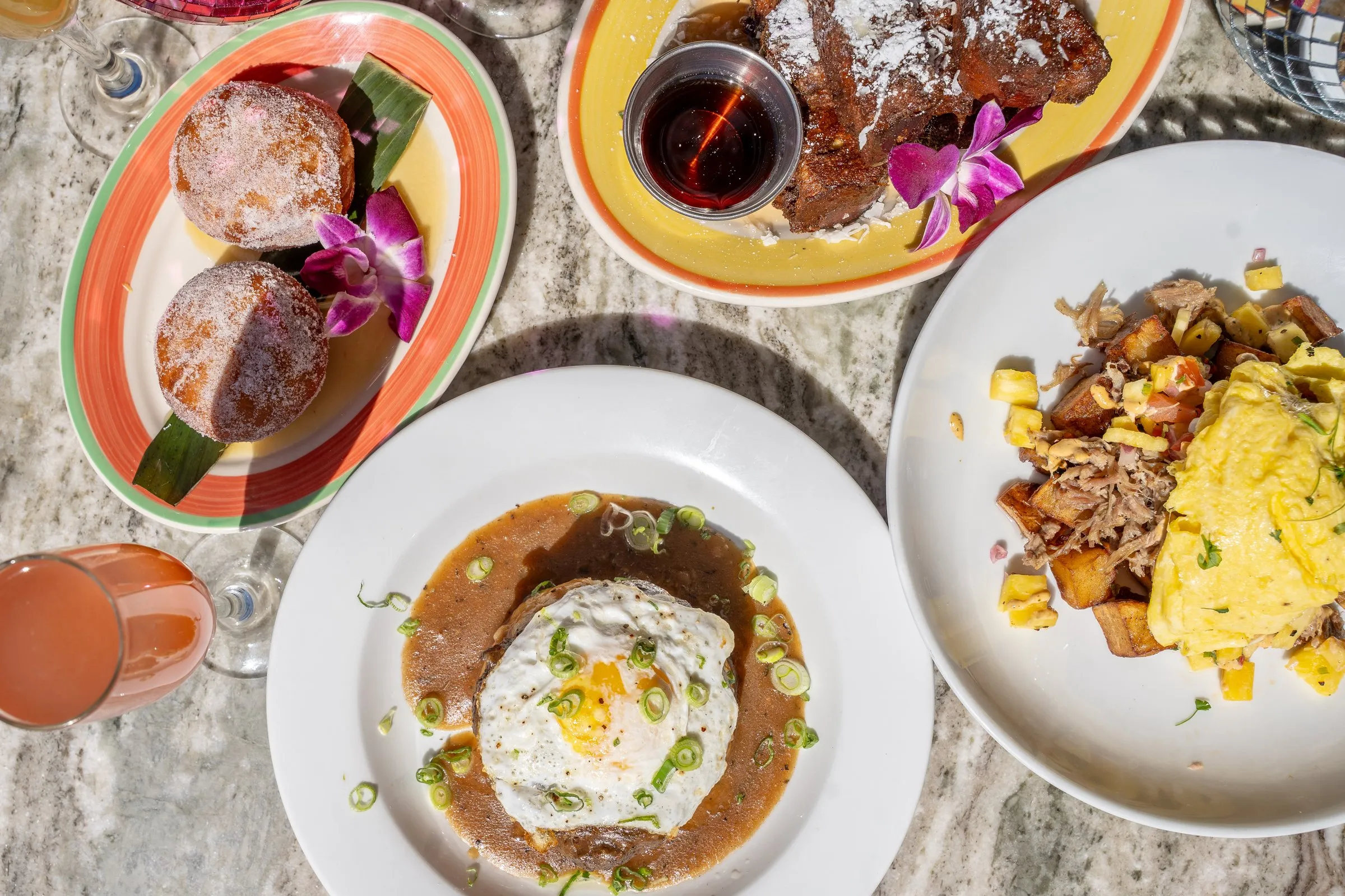 Coco Cabana weekend brunch spread — colorful plates, eggs, French toast on marble table