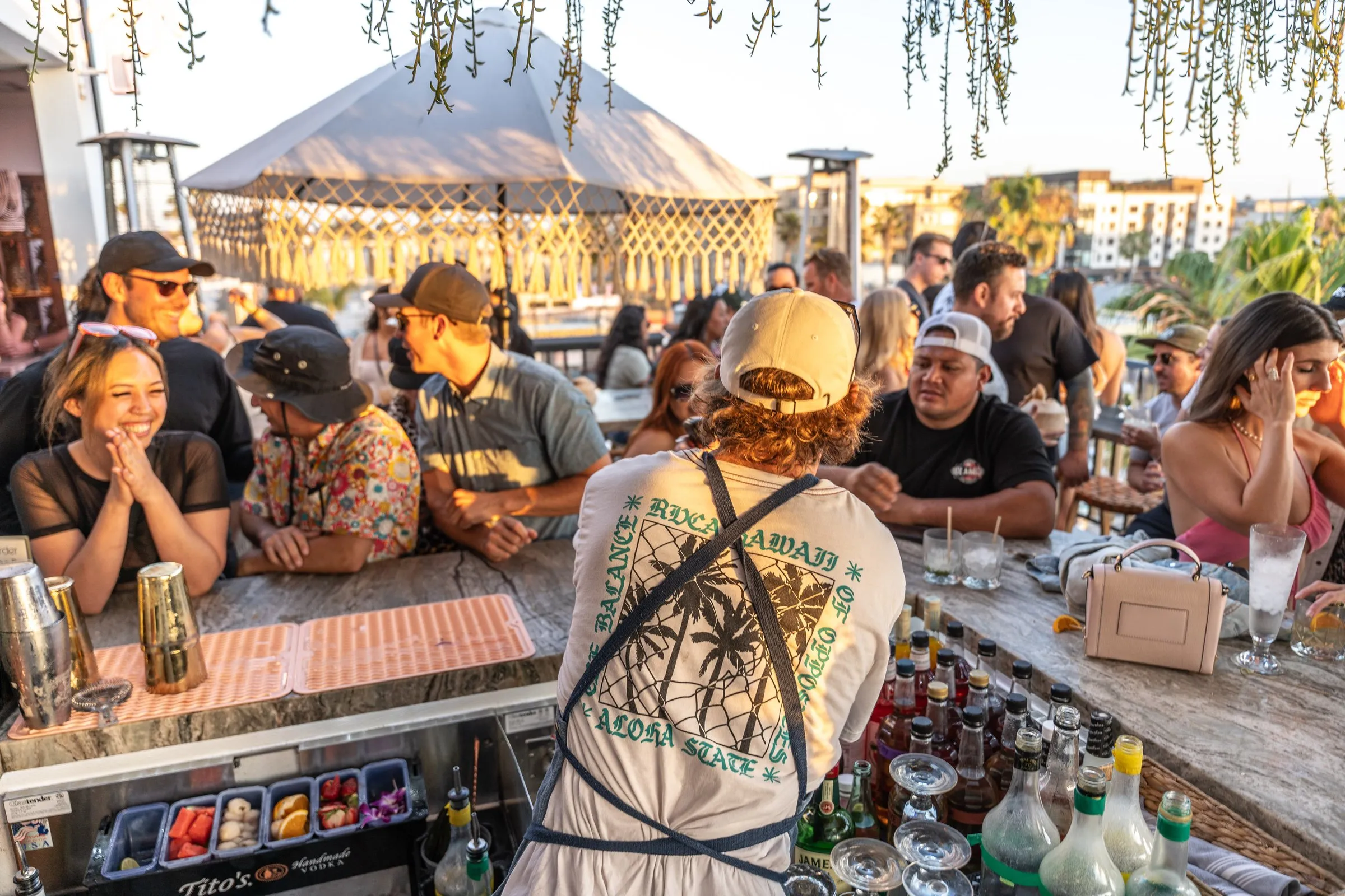 Coco Cabana rooftop packed with guests at golden hour — bartender at full venue